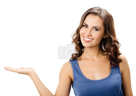 Téléchargez les photos : Joyeux sourire belle jeune femme montrant l'espace de copie ou quelque chose, isolé sur fond blanc - en image libre de droit