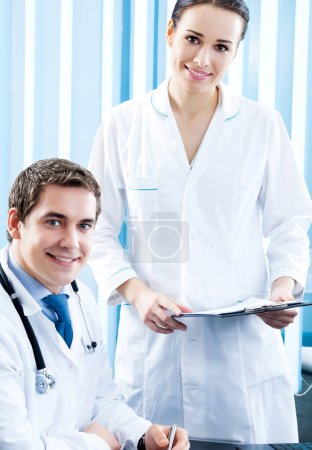 Téléchargez les photos : Deux médecins heureux qui travaillent ensemble au bureau - en image libre de droit