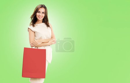 Foto de Mujer feliz con bolsas de compras, sobre fondo verde, con espacio de copia para algún eslogan, publicidad o texto - Imagen libre de derechos