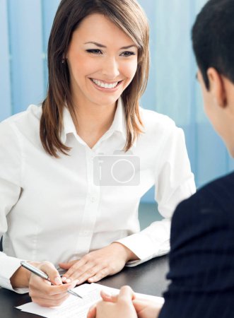 Photo for Two young businesspeople, or business woman and client, working at office - Royalty Free Image