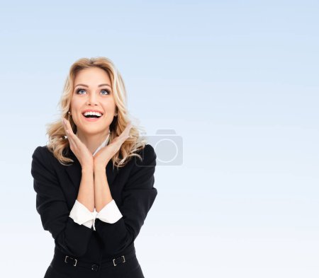 Photo for Happy gesturing young businesswoman, on blue background, with blank copy space area for some advertising, text or slogan - Royalty Free Image