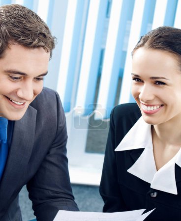 Photo for Two happy smiling cheerful young businesspeople working with documents at office - Royalty Free Image