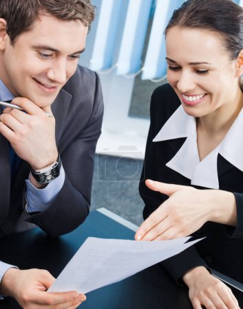 Photo for Two happy smiling cheerful young businesspeople working with documents at office - Royalty Free Image
