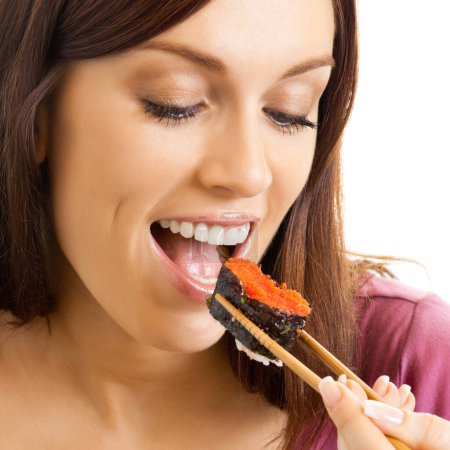 Photo for Portrait of cheerful beautiful woman eating sushi roll with chopsticks, isolated over white background - Royalty Free Image