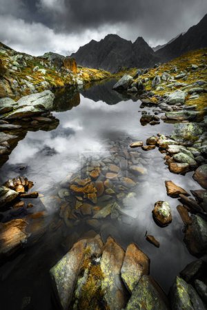 Téléchargez les photos : Un petit lac de montagne en arrière-plan avec des montagnes rocheuses des Alpes Stubai - en image libre de droit