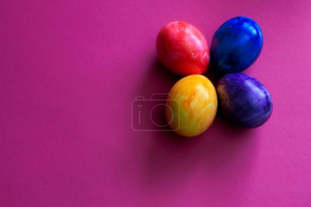Téléchargez les photos : Oeufs de Pâques de différentes couleurs sur un fond coloré - en image libre de droit