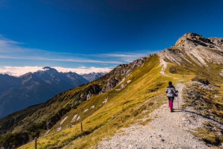 Téléchargez les photos : Vue du paysage alpin de montagne depuis l'Autriche avec une touriste féminine - en image libre de droit
