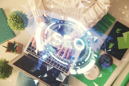 Photo for Double exposure of woman hands working on computer and SEO hologram drawing. Top View. Search optimization concept. - Royalty Free Image