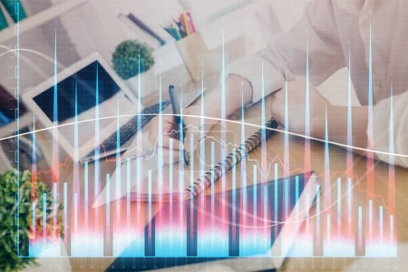Photo for Financial graph displayed on woman's hand taking notes background. Concept of research. Double exposure - Royalty Free Image
