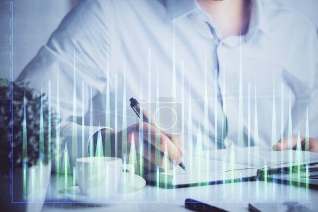 Photo for Double exposure of man's hands writing notes of stock market with forex graph background. Concept of research and trading. - Royalty Free Image