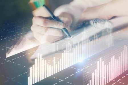Photo for Financial forex graph displayed on hands taking notes background. Concept of research. Double exposure - Royalty Free Image