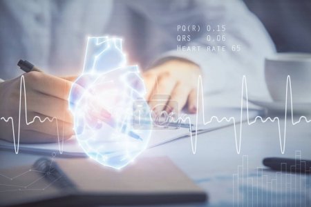 Photo for Heart hologram over woman's hands writing background. Concept of Medical education study. Double exposure - Royalty Free Image