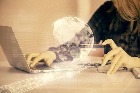 Photo for Double exposure of woman on-line shopping holding a credit card and world map hologram drawing. International E-commerce concept. - Royalty Free Image