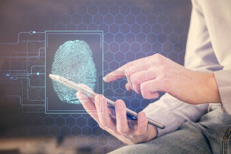 Photo for Double exposure of man's hands holding and using a digital device and fingerprint hologram drawing. Security concept. - Royalty Free Image