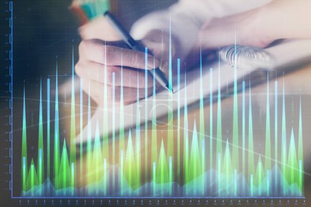 Photo for Financial forex graph displayed on hands taking notes background. Concept of research. Double exposure - Royalty Free Image