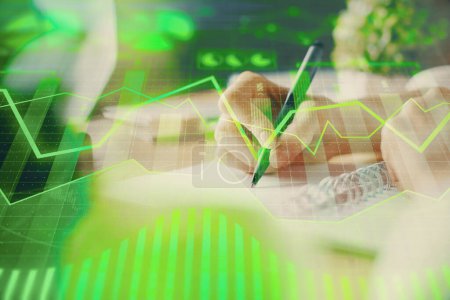 Photo for Financial forex graph displayed on hands taking notes background. Concept of research. Multi exposure - Royalty Free Image