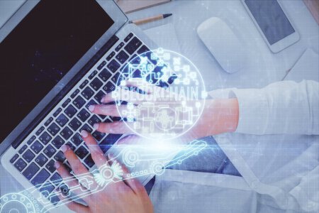 Téléchargez les photos : Double exposition des mains de la femme travaillant sur l'ordinateur et le thème blockchain hologramme dessin. Vue du dessus. Bitcoin concept crypto-monnaie. - en image libre de droit