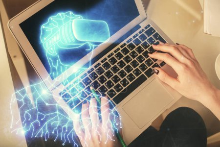 Téléchargez les photos : Double exposition des mains de la femme travaillant sur ordinateur et l'homme dans les lunettes ar hologramme dessin. Vue du dessus. Concept de réalité virtuelle
. - en image libre de droit