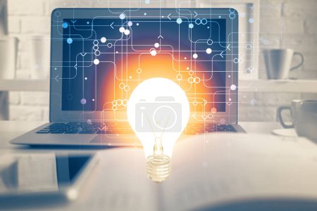 Photo for Computer on desktop in office with bulb icon hologram. Multi exposure. Concept of idea. - Royalty Free Image