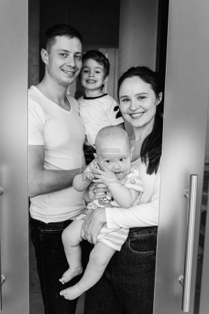 Photo for Black and white classic portrait. Young, emotional, cheerful, big family, mother, father and sons are standing looking at the camera, smiling emotions. - Royalty Free Image