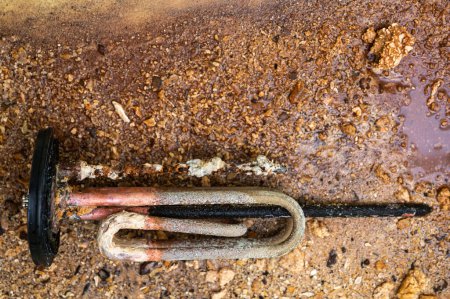 Photo for Heating element of an electric water heater with a rusty anode and a tube covered with scale, a damaged part. Maintenance and repair. - Royalty Free Image