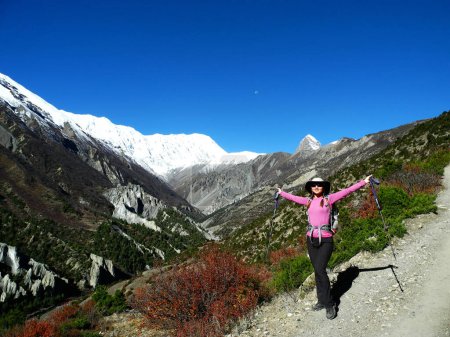 Téléchargez les photos : Jeune femme aux mains écartées face au soleil en Himalaya. Randonnées et activités au Népal. - en image libre de droit