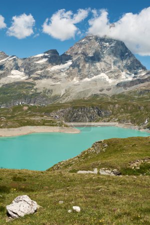 Photo for Matterhorn mountain with lake Goillet and the weir. Green alpine meadow in the foreground - Royalty Free Image
