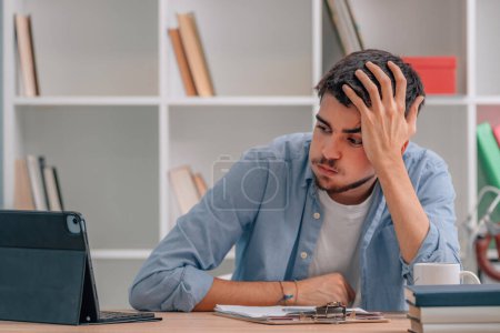 young student at home stressed looking at computer or laptop