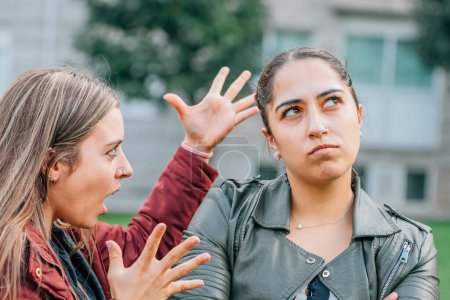 Téléchargez les photos : Two female friends arguing in the street outdoors - en image libre de droit