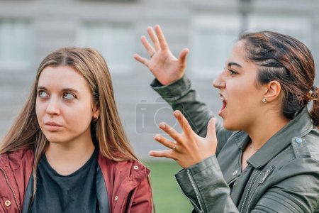 Téléchargez les photos : Two female friends arguing in the street outdoors - en image libre de droit