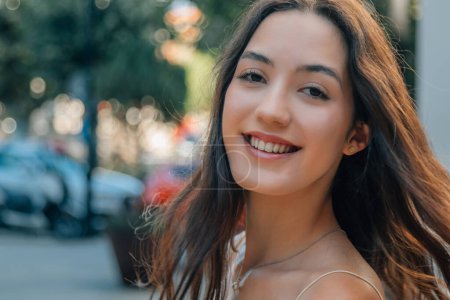 Téléchargez les photos : Jeune fille caucasienne regardant caméra dans la rue avec les cheveux dans l'air - en image libre de droit