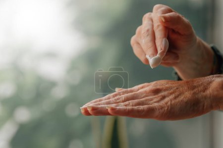hands with anti-aging moisturizing cream