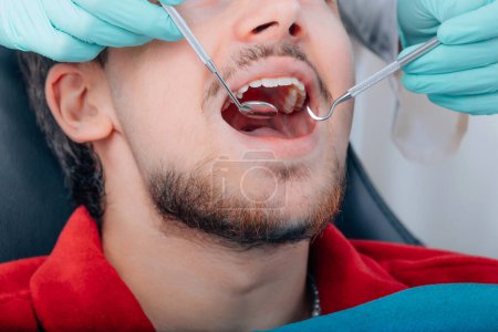 Téléchargez les photos : Patient au cabinet dentaire, mains avec les outils du dentiste - en image libre de droit