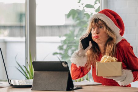 middle aged woman in santa claus costume with mobile phone and expression of stress
