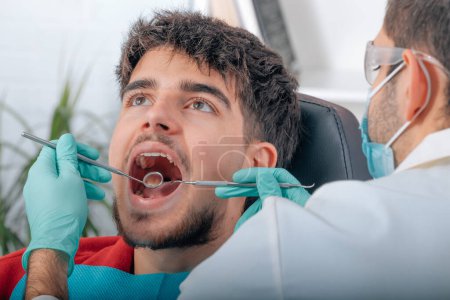 Photo for Dentist working with tools in patient's mouth - Royalty Free Image