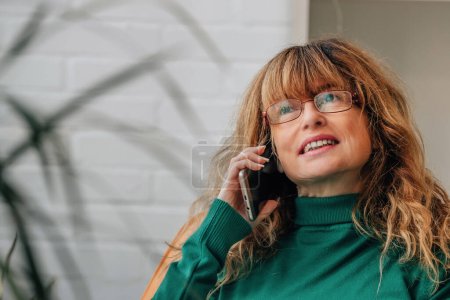 Photo for Middle-aged adult woman talking on mobile phone - Royalty Free Image