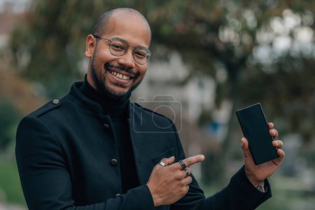 Foto de Hombre apuntando a móvil o celular en la calle - Imagen libre de derechos