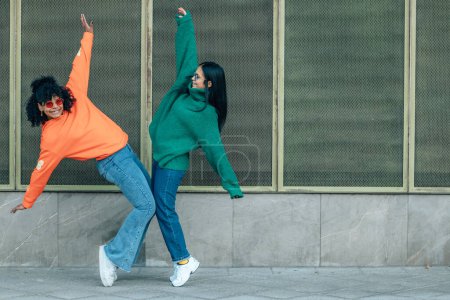 Téléchargez les photos : Filles dans la rue dansant avec maillot de couleur - en image libre de droit
