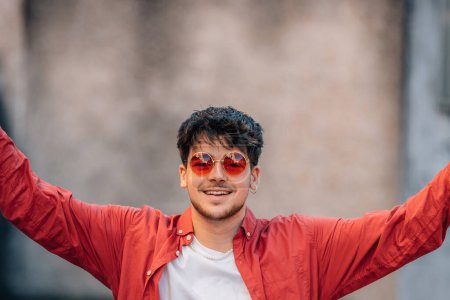 Téléchargez les photos : Portrait de jeune homme avec des lunettes de soleil avec expression de joie - en image libre de droit