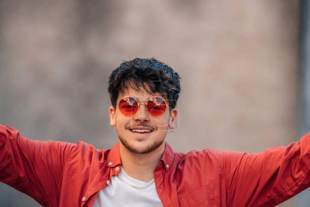 Téléchargez les photos : Portrait de jeune homme avec des lunettes de soleil avec expression de joie - en image libre de droit