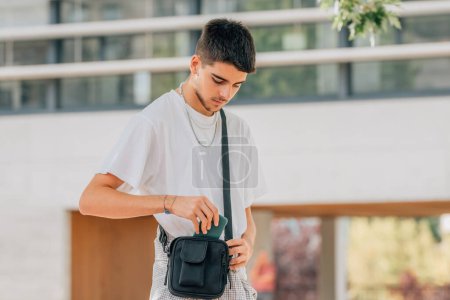 Photo for Young man on the street keeping the mobile phone - Royalty Free Image