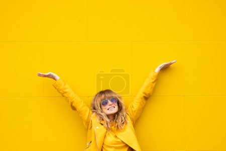 Téléchargez les photos : Femme d'âge moyen excité avec bonheur sur fond jaune à l'extérieur - en image libre de droit