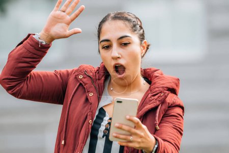 Téléchargez les photos : Surprised girl looking at mobile phone - en image libre de droit