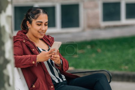 Mädchen mit Handy im Herbst im Park
