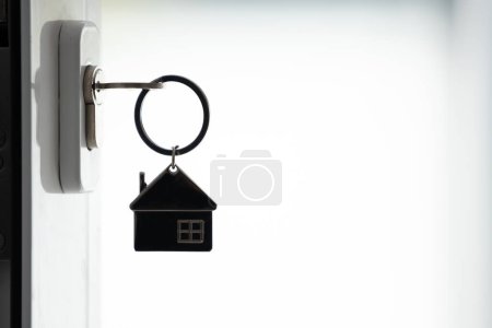 Téléchargez les photos : Silhouette de la clé de la maison dans la serrure de porte - en image libre de droit