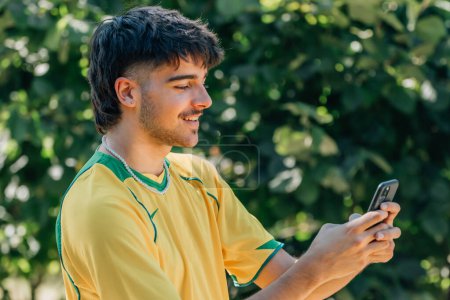 smiling young man watching the game or video on the mobile phone, sport