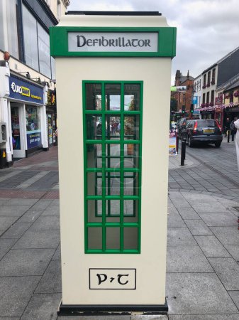 Foto de Killarney, Irlanda - 15 de julio de 2018: La cabina telefónica tradicional irlandesa es la casa de un desfibrilador - Imagen libre de derechos