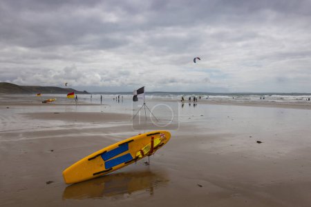 Photo for Newgale, Wales - August 29, 2023: Lifeguard surfboard on the Newgale Beach suitable for kitesurfing - Royalty Free Image