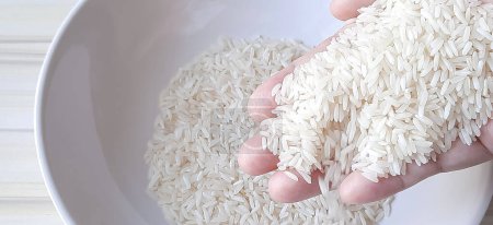 Foto de Arroz blanco, arroz jazmín, en la mano de la gente, vista superior. - Imagen libre de derechos
