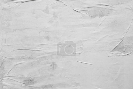 Photo for Blank white crumpled and creased paper. White sheet of crumpled paper glued to the wall. - Royalty Free Image